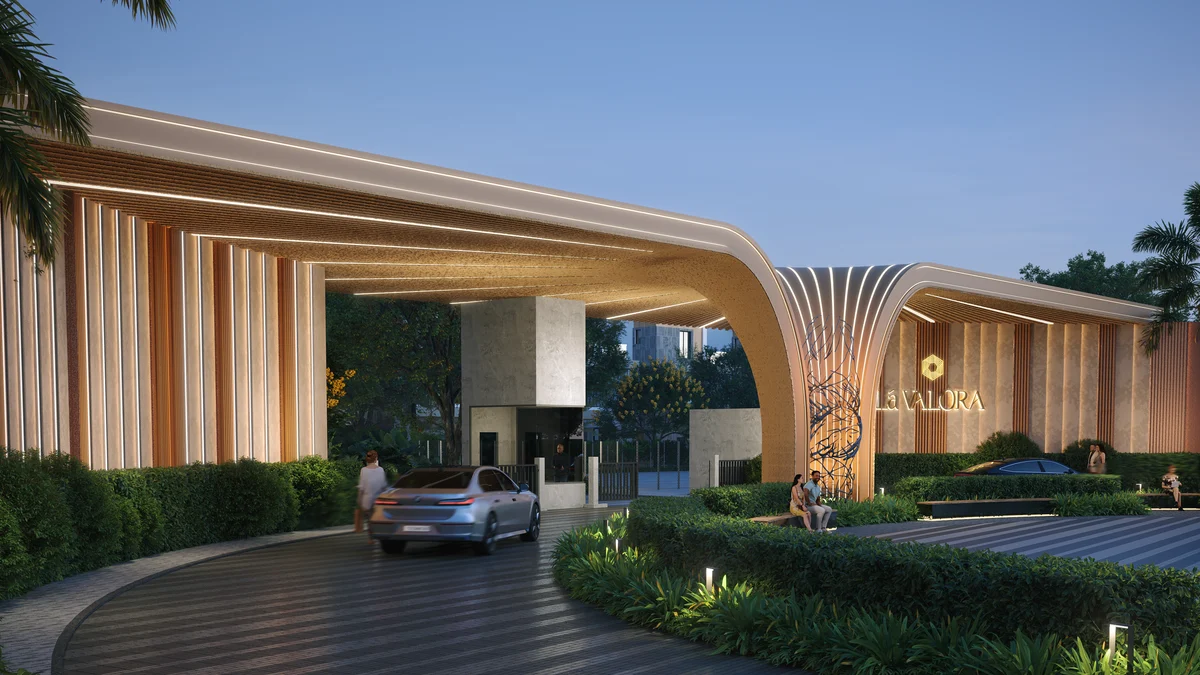 Revasa Là Valora entrance gateway at dusk, a curved slatted canopy over the arrival drive with the Là Valora sign